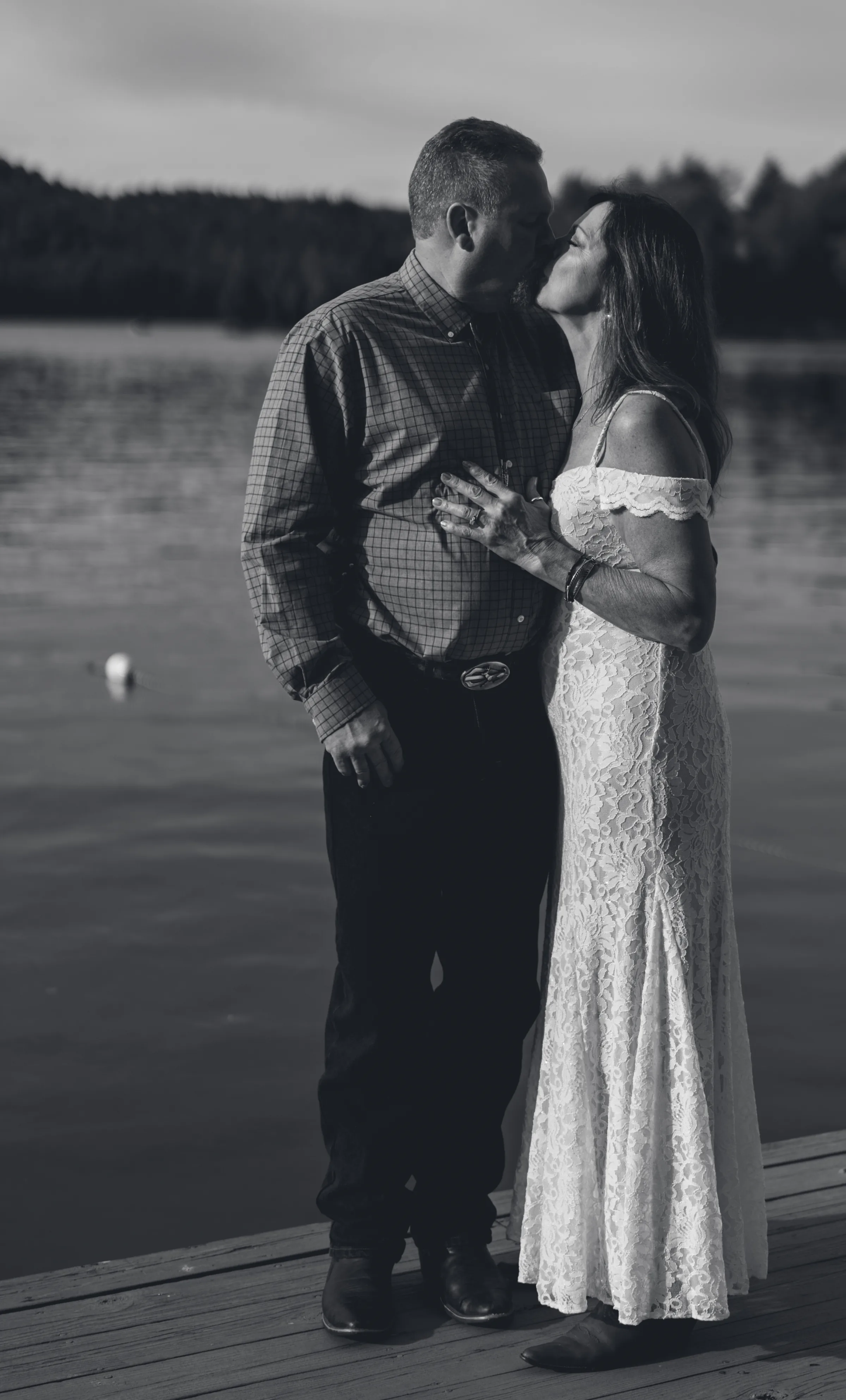 Black and white portrait of a couple embracing beside a lake