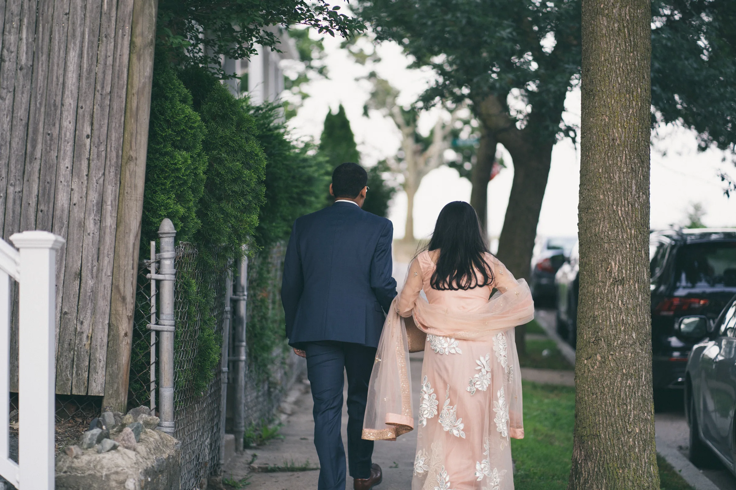 Couple walking together along a tree-lined garden path