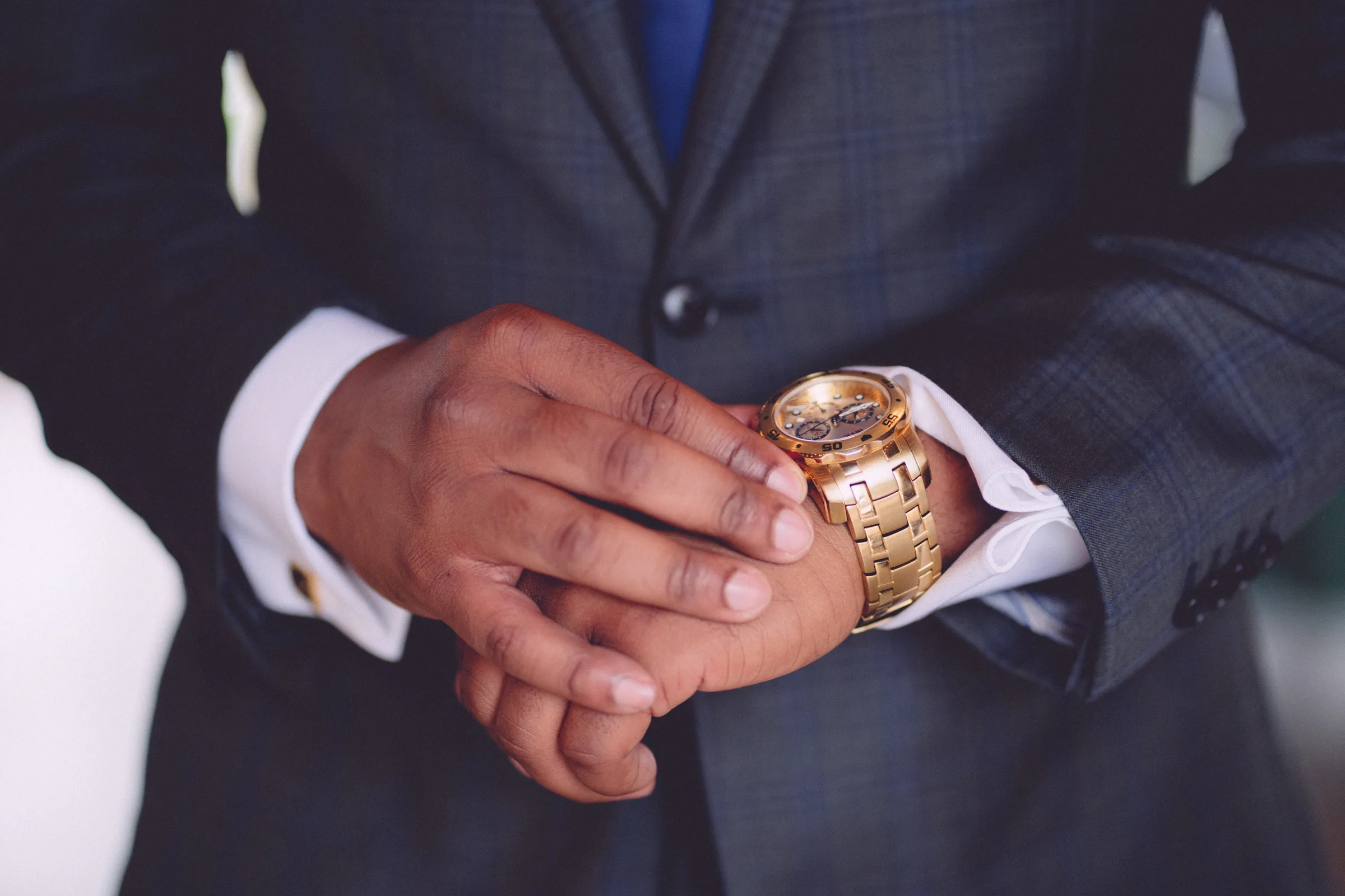 Groom's hands, watch, and wedding suit photographed before the ceremony