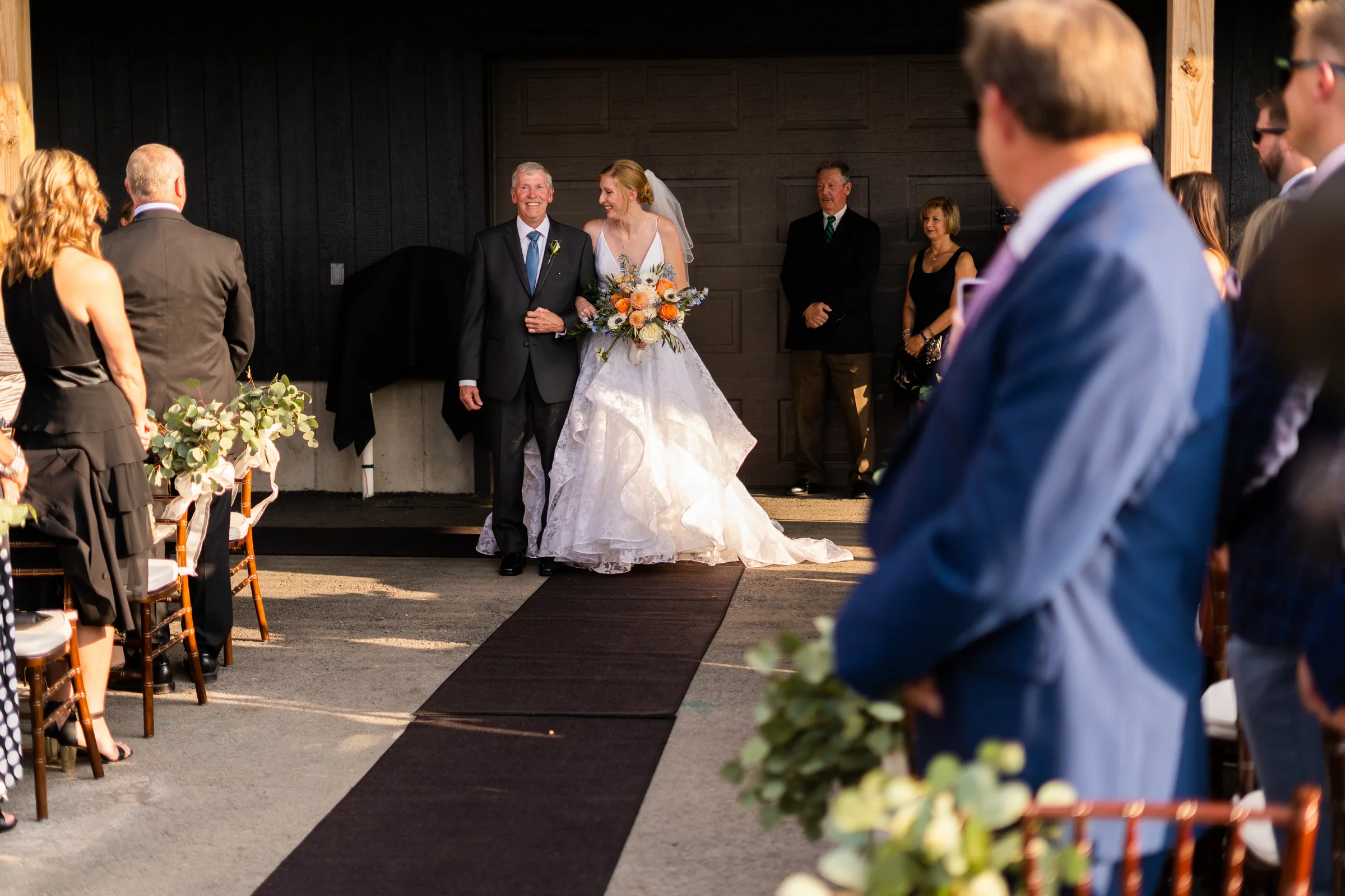Bride entering the wedding ceremony as the groom watches from the foreground