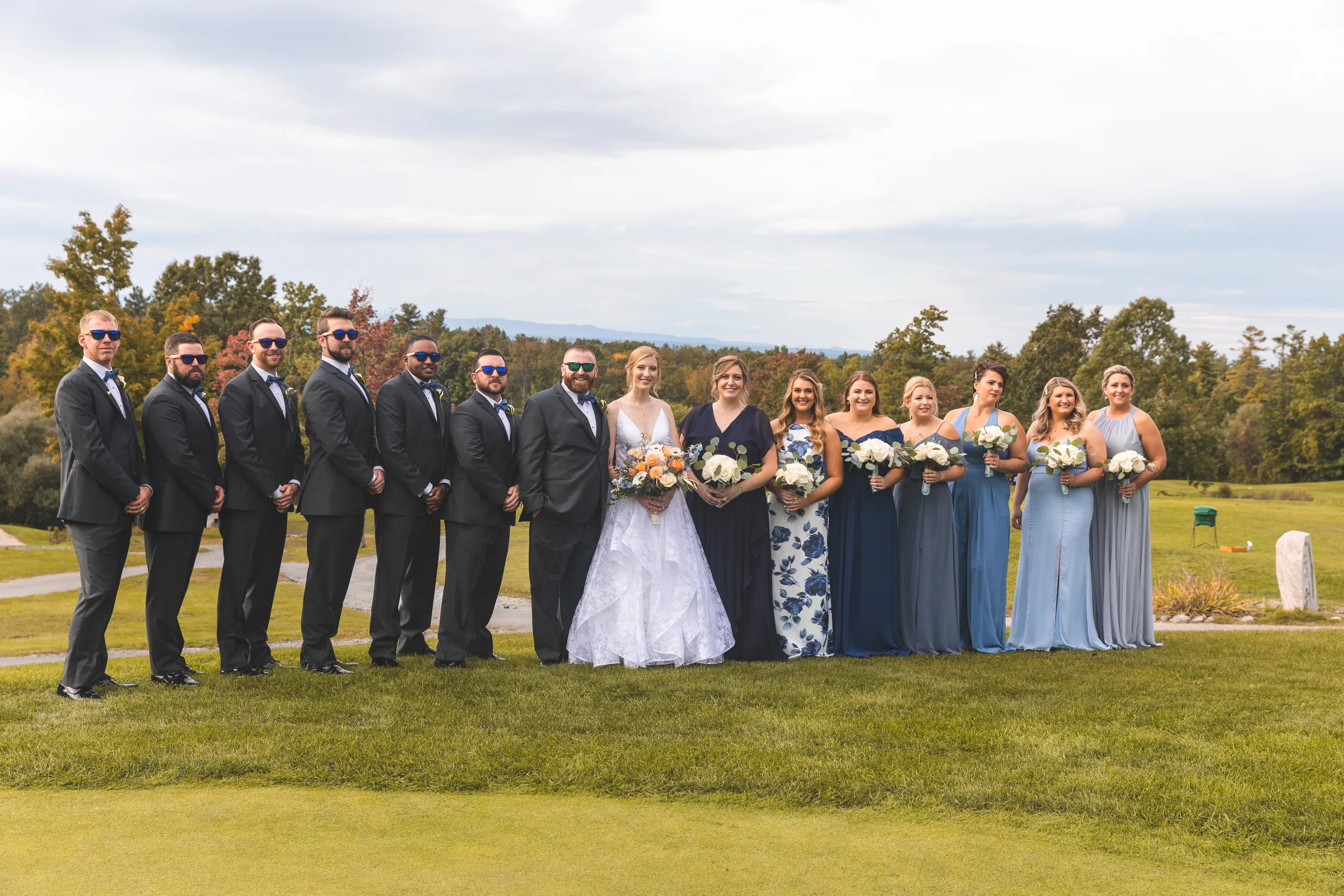 Bride and groom with their wedding party standing together in a garden